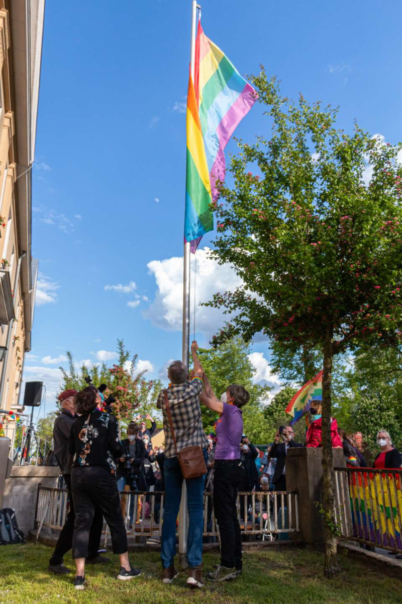 Julia Concu, Harald Petzold und Martina Hape hissen die Regenbogenfahne
