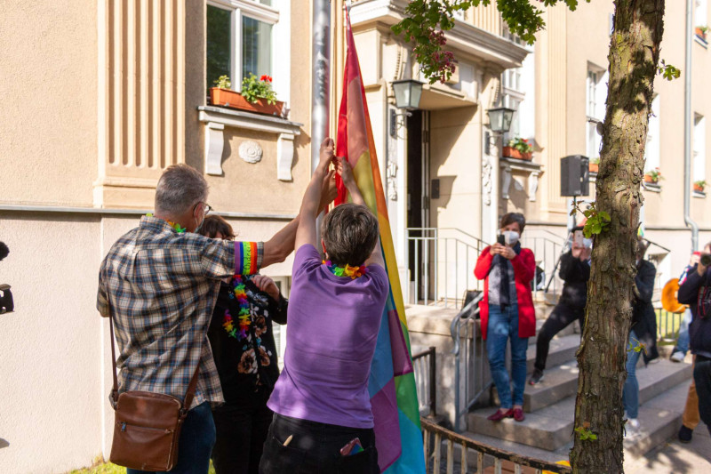 Gemeinsam wird die Regenbogenfahne am Rathaus gehisst